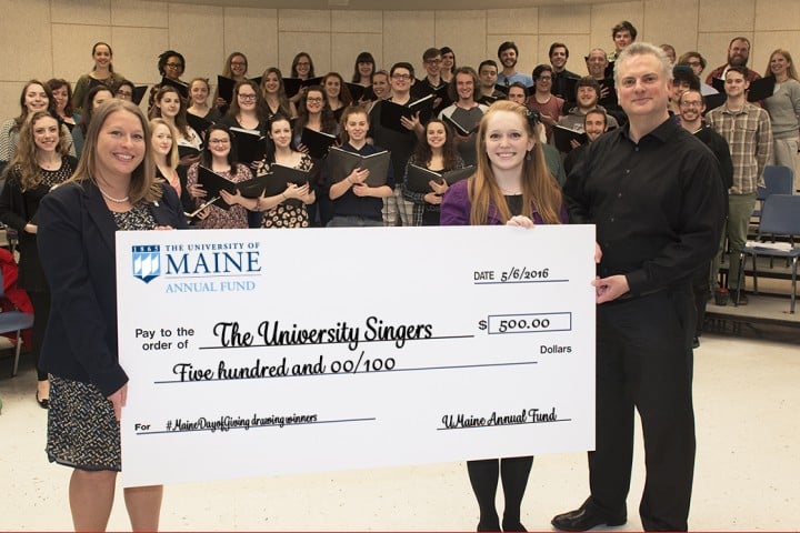 The University Singers accept a $500 check from Christina Caron of the UMaine Annual Fund